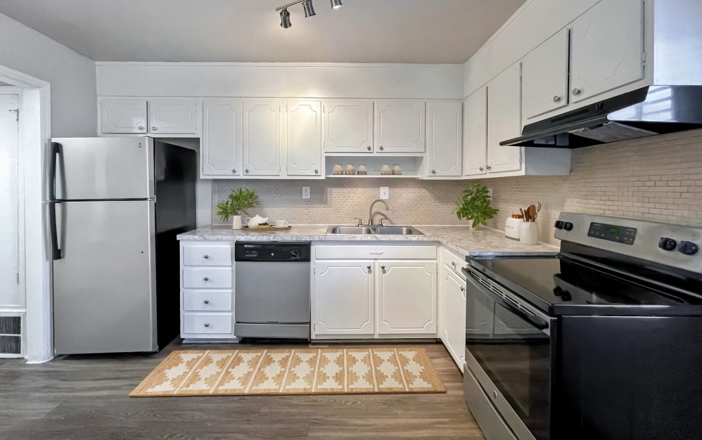 Townhome kitchen with white cabinets and stainless steel appliances